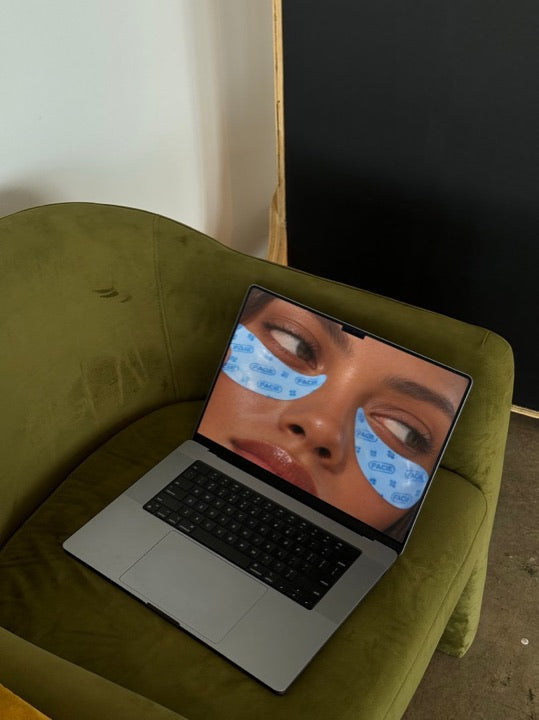 A laptop on a green chair with a design on screen, a real Mock Exchange mockup