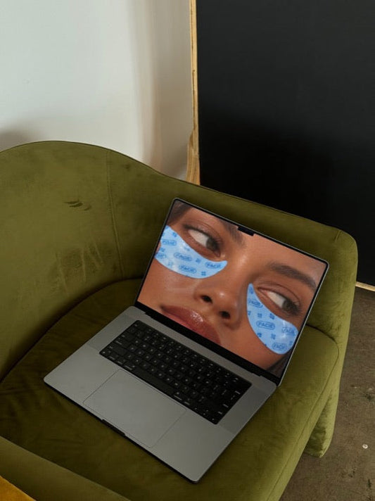 A laptop on a green chair with a design on screen, a real Mock Exchange mockup